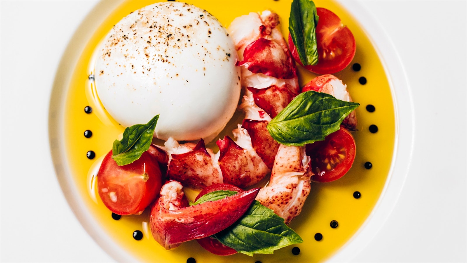A plate of Maine lobster caprese, with mozzarella and basil leaves